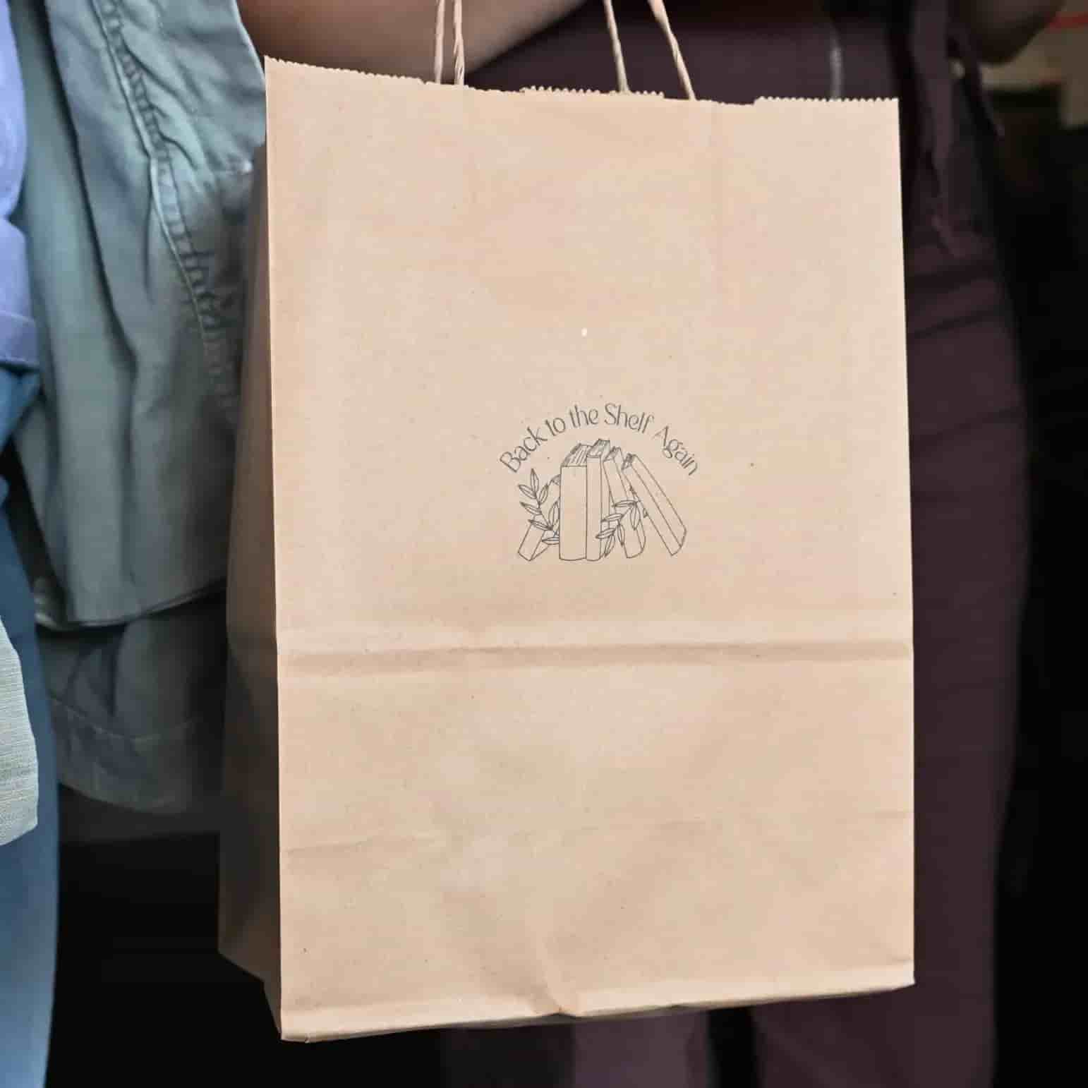 A paper bag with a "Back to the Shelf Again" logo stamp